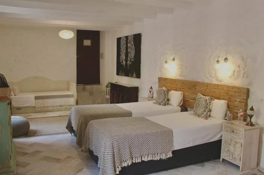 Dormitorio con cabecero artesanal de madera noble en Cortijo San José